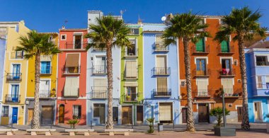 Panorama of colorful houses and palm trees in Villajoyosa, Spain clipart