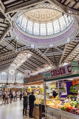 Vegetable stall with people at the Mercado Central of Valencia, Spain clipart