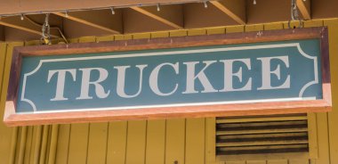 Wooden sign at the wall of the Truckee railway station in California, USA clipart