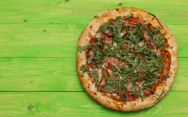 緑の木製テーブルにロケット サラダ ゴルゴンゾーラとベーコンのピザ — ストック写真