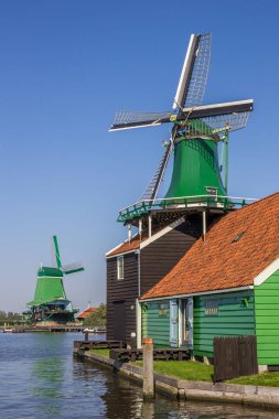 Traditional dutch windmills at the Zaan river in Zaanse Schans, Netherlands clipart