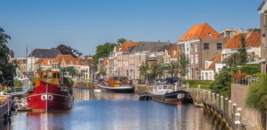 Panorama of a canal with old ships and historical houses in Zwolle, The Netherlands clipart
