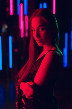 Neon tüplerin seksi iç çamaşırı ve tam openned kimono bir duvara duran çekici genç kadın portresi