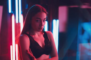 Seksi iç çamaşırı ayakta aynalar ve neon ışıkları bir odada çekici genç kadın portresi tarafından kırmızı ışık yaktı
