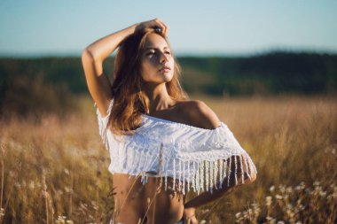 Çekici kızı ince uzun otların alanına sunset Bulvarında poz vücut ayakta uygun