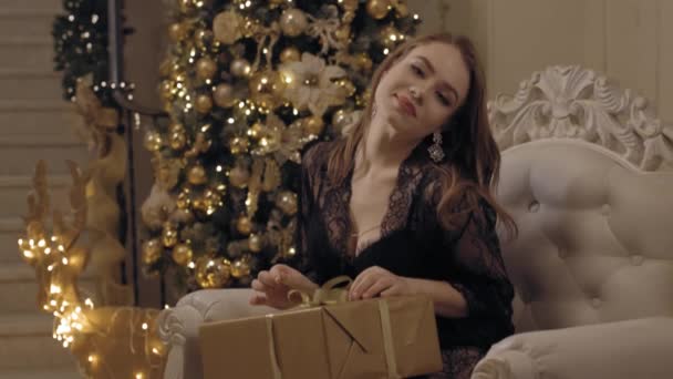 Joven mujer atractiva en encaje peignoir jugando con su regalo de Navidad — Vídeo de stock