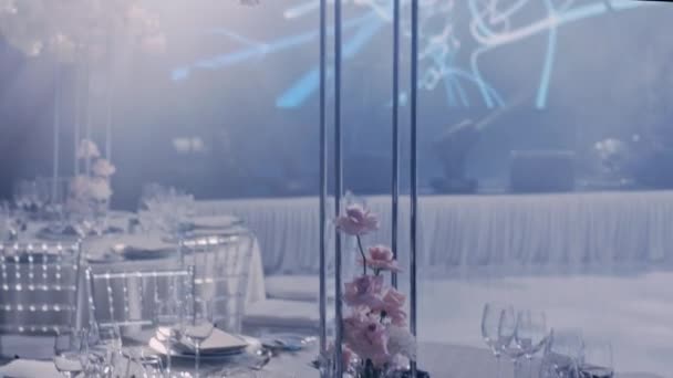 Kamera dreht sich von links nach rechts um einen hochzeitsgeschmückten Tisch mit einem Strauß. — Stockvideo