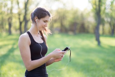 Akıllı telefonu olan sportif bir kadın.