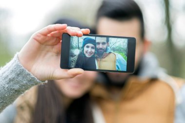 Genç bir kadın akıllı telefonuyla fotoğraf çekiyor.