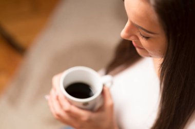 Genç bayan kafede kahve içiyor.