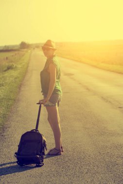 Yoldaki bavullu genç kadın.