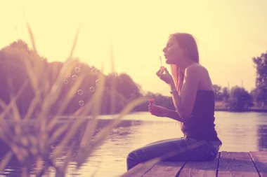 Gün batımında gölde balon üfleyen kadının eski bir fotoğrafı.