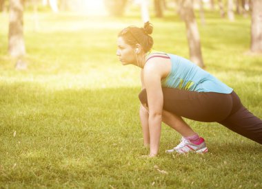 Park 'ta esneme hareketleri yapan genç bir kadın.