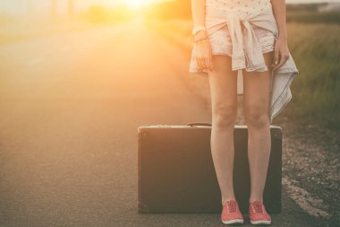 Yoldaki bavullu genç kadın.