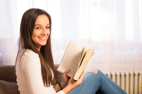 Hermosa Joven Leyendo Libro Mientras Está Sentada Sofá Casa —  Fotos de Stock