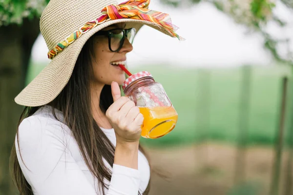Avslappnande Kvinna Och Dricka Kall Apelsinjuice — Stockfoto
