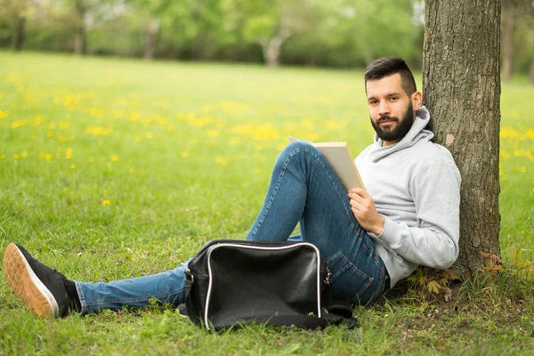 Jonge Man Die Het Gras Zit Naar Muziek Luistert — Stockfoto