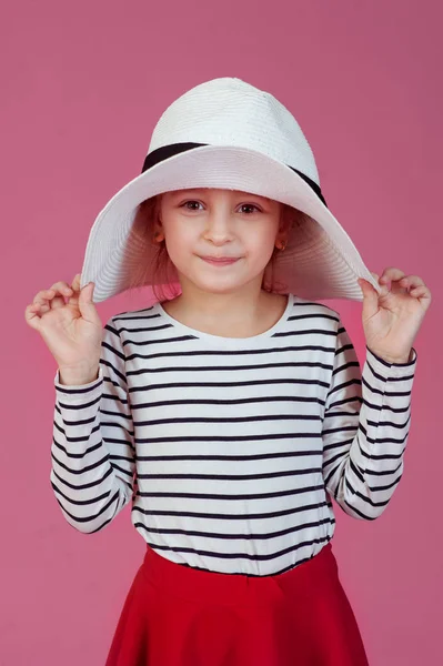 Happy little girl in white hat at pink studio background. — Stock Photo, Image