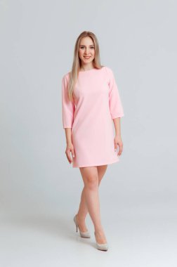Tam uzunlukta portre Studio beyaz arka plan üzerinde izole poz pembe içinde mutlu güzel kadın