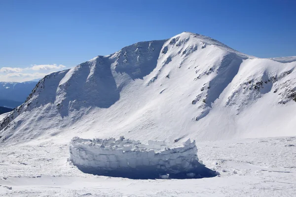 Schneemauer vor dem Hintergrund der Berge — Stockfoto