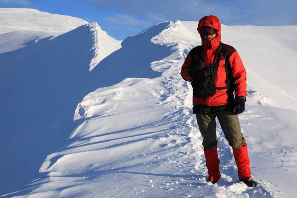 Turisten står på åsen av bergen i vinter m — Stockfoto