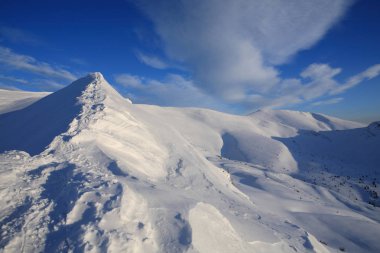 Mountai karla kaplı yamaçları üzerinde parlak mavi gökyüzü