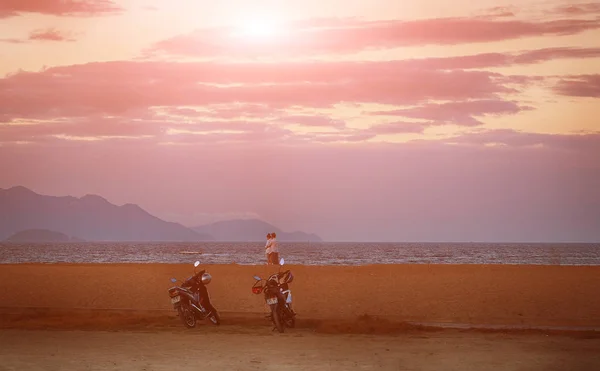 Nhatrang, Vietnam 'da güneşin doğuşunu izleyen romantik moto çifti.