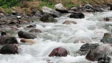 Geçitteki kayalar arasında hızlı dağ akıntısı, hızlı su akışı kaynar ve köpükler, su sıçramaları, Kırgızistan, Tien Shan