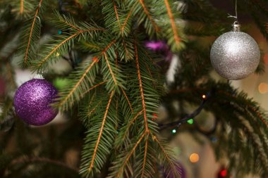 Menekşe ve parlak oyuncak ile dekore edilmiş güzel ve zarif yeni yıl ağacı