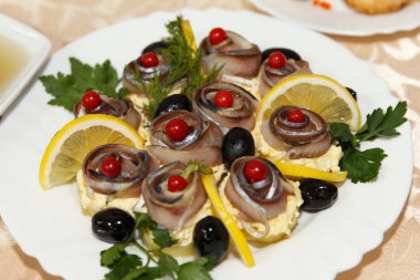 Balık yağı, zeytin sandviç, bir plaka üzerinde limon ve kırmızı meyveler