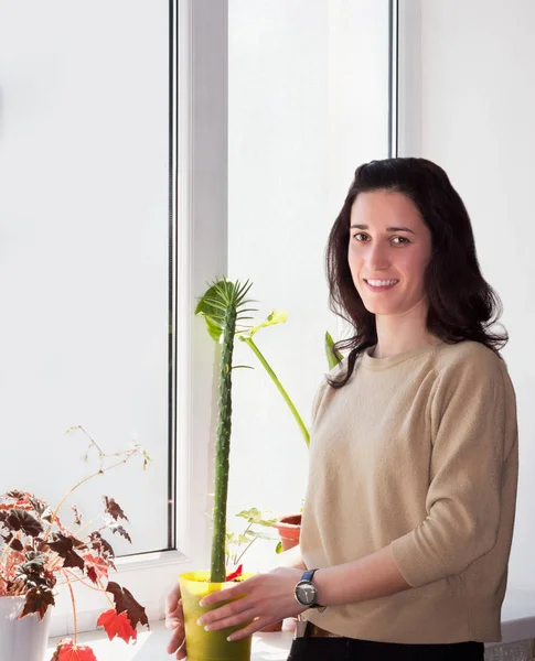 Menina cuida das flores do quarto — Fotografia de Stock