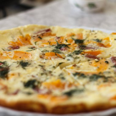 Portakal domatesli, dolmalık biberli, otlu ve jambonlu lezzetli bir omlet. Tabak beyaz bir tabakta servis edilir, parçalara ayrılır, kahvaltı için.