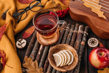 Düz yatıyordu. Desenli eşarp çay ile. Sonbahar yaprakları ahşap arka plan üzerinde. Sonbahar ya da kış konsepti.