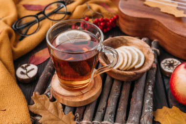 Düz yatıyordu. Desenli eşarp çay ile. Sonbahar yaprakları ahşap arka plan üzerinde. Sonbahar ya da kış konsepti.