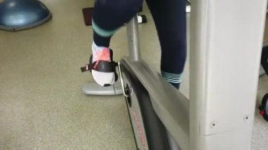 Spor salonunda egzersiz bisikleti üzerinde çalışan çekici kız ... 4k'da çekilmiş.