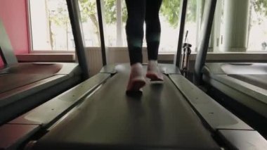 Spor salonunda koşu bandında çalışan çekici kız... 4k'da çekilmiş.