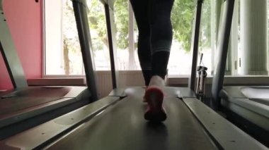 Spor salonunda koşu bandında çalışan çekici kız... 4k'da çekilmiş.