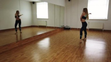 Dans stüdyosunda prova sırasında zarif çekici kadın dansçı doğaçlama çağdaş bir tarzda dans. Pürüzsüz zarif dans performans neşeli yaratıcı kadın kapalı eğitim sınıf sırasında hareket eder..