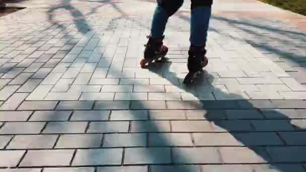 公園で若い美しい女の子ローラースケート 路地で美しい日当たりの良い春の日に若い女性のローラーブレード — ストック動画