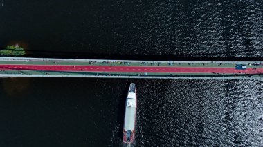 Yaya köprüsünde havadan şehir manzara trafiği. Köprü altında gemi