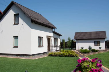 Yeşil çimenli, dış görünüşlü modern bir ev.