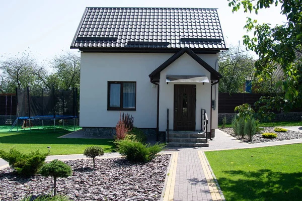 Yeşil çimenli, dış görünüşlü modern bir ev.
