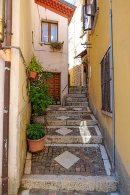 İtalya 'nın Potenza ilindeki küçük bir ortaçağ kasabası olan Pescopagano' nun eski evleri arasında bir sokak..