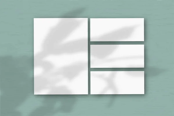 Několik Horizontálních Vertikálních Listů Bílého Strukturovaného Papíru Pozadí Zelené Stěny — Stock fotografie