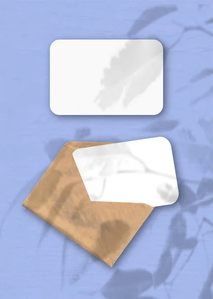 Egy Boríték Két Lap Texturált Fehér Papírral Kék Háttéren Mockup — Stock Fotó