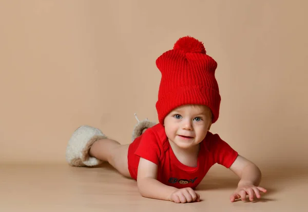 Piccolo bambino carino sdraiato sul pavimento guardando dritto alla fotocamera — Foto Stock