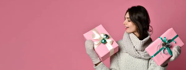 Vrolijke vrouw in grijze trui bedrijf houdt twee geschenken en plezier — Stockfoto