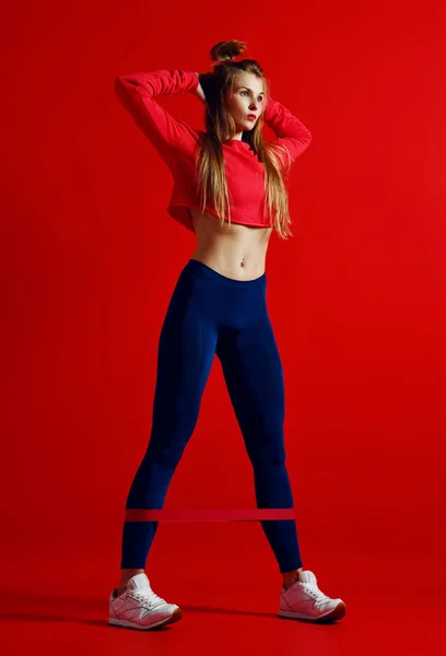 Frau mit gutem Körperbau beim Stretching mit Gummibändern. — Stockfoto