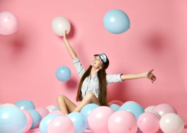 Birçok renk hava balonları balonlar, pembe arka plan izole zevk arayan sahip moda neşeli genç kadın portresi.
