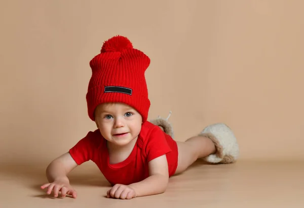 Piccolo bambino carino sdraiato sul pavimento guardando dritto alla fotocamera — Foto Stock